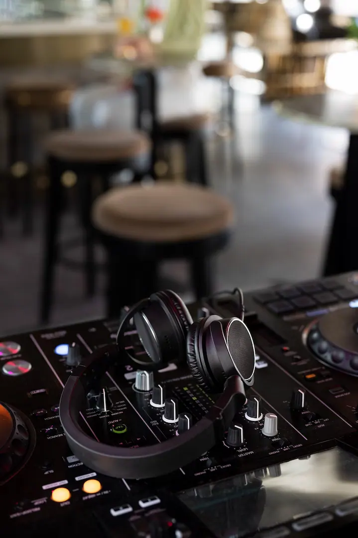 Headphones resting on a DJ controller in an empty venue