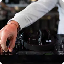 A hand reaching across DJ decks